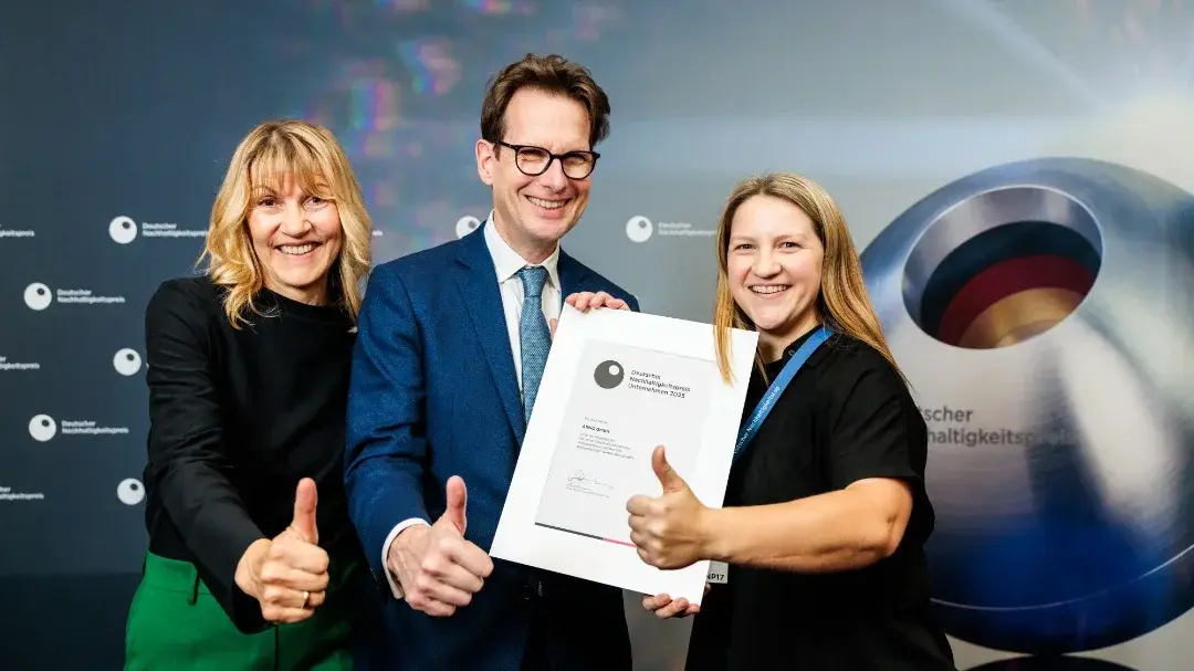 two arno employees and one man giving thumbs up and holding dnp finalist's certificate