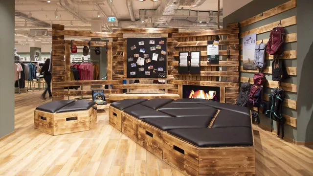 Sitzbank ruht im modernen Holzinnenraum eines sportlichen Bekleidungsgeschäfts