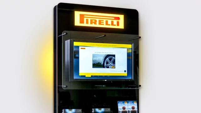 Display screen showcasing tire advertisement in a modern retail store