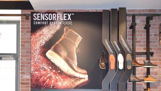 Boots displayed on shelves in brick-walled store