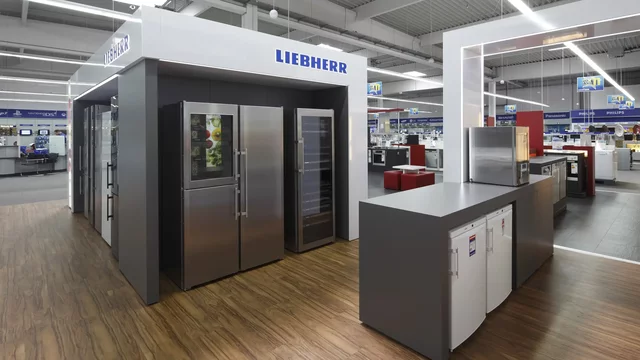 Kühlschränke stehen im Elektrofachmarkt auf hölzernem Boden
