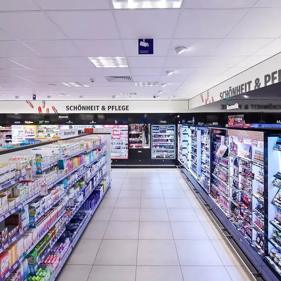 Shelves display beauty products in a bright, organized cosmetic store aisle