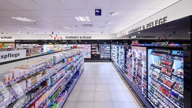 Kosmetikprodukte stehen im Regal, beleuchtet in einem modernen Drogeriemarkt