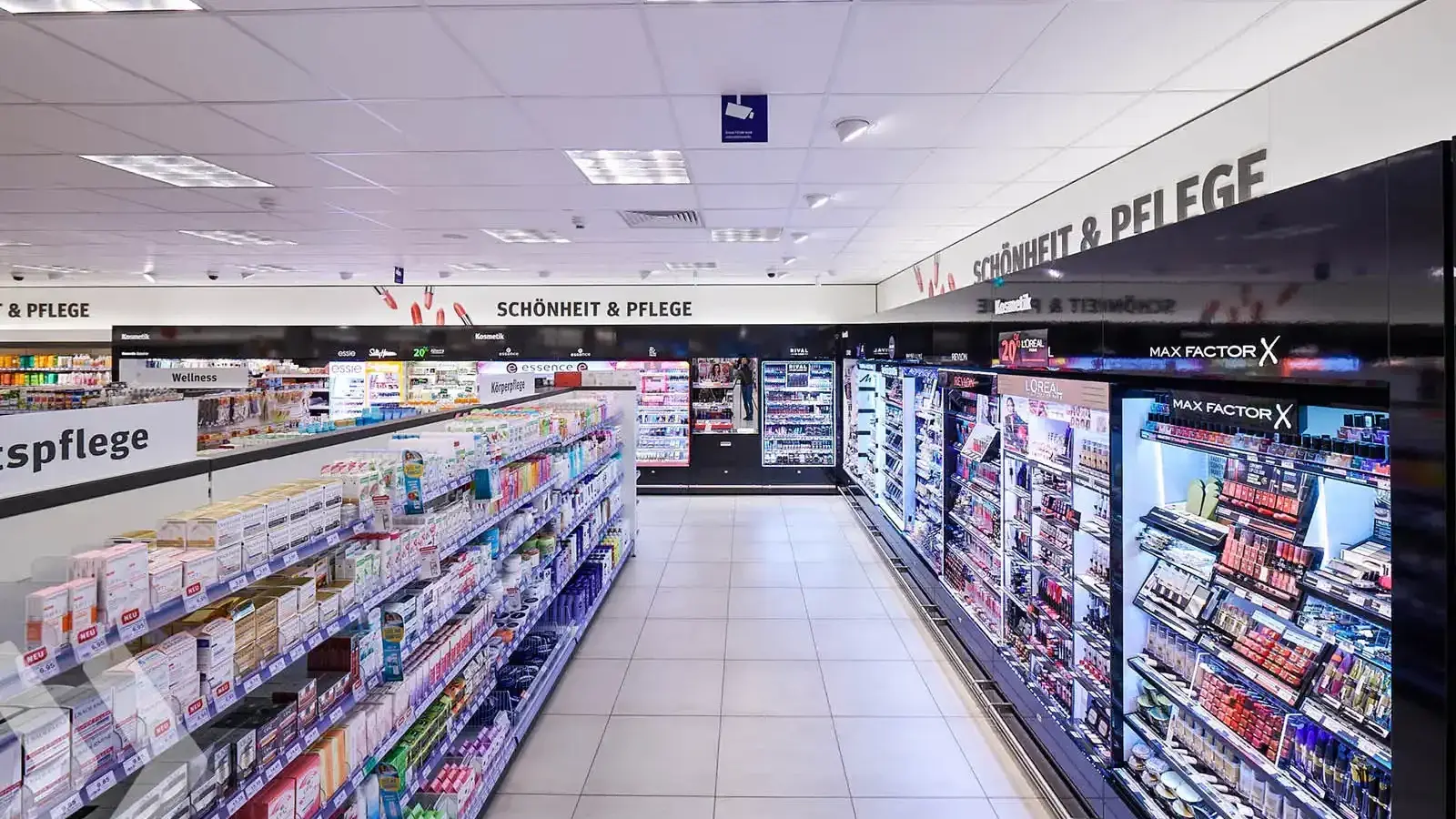 Shelves display beauty products in a bright, organized cosmetic store aisle