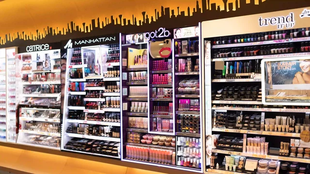 Kosmetikregale präsentieren vielfältige Make-up-Produkte in einem gut beleuchteten Geschäft