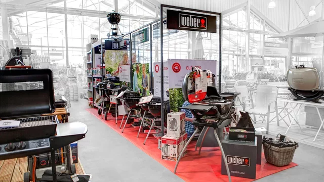 Weber grills displayed on red floor, indoor showroom