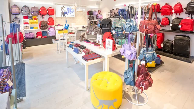 Backpacks displayed on racks in a brightly lit retail store