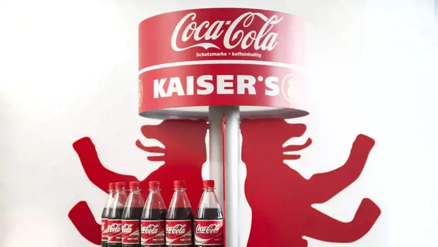 Coca-Cola bottles displayed on a three-tiered red bear-shaped stand