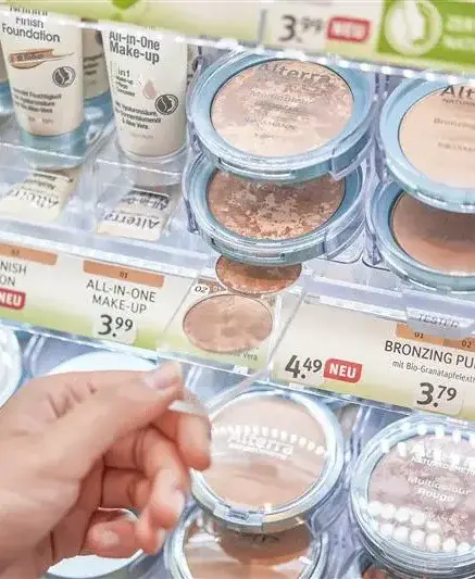 Hand reaching for makeup in a cosmetic store display
