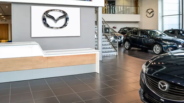 Cars displayed in showroom with bright, modern interior and staircase